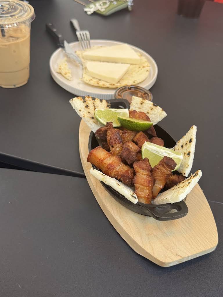 Plato de chicharrón crujiente con acompañantes en Aromas